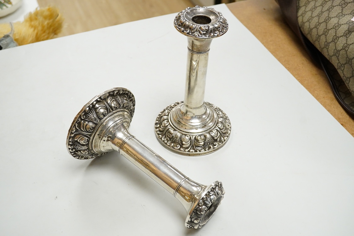 A pair of Edwardian silver mounted candlesticks, with embossed scroll bases, Martin, Hall & Co, Birmingham, 1906, height 19cm, weighted, (a.f.).